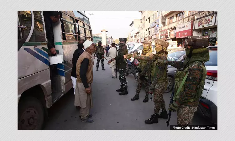 Security personnel stop commuters  in Srinagar.