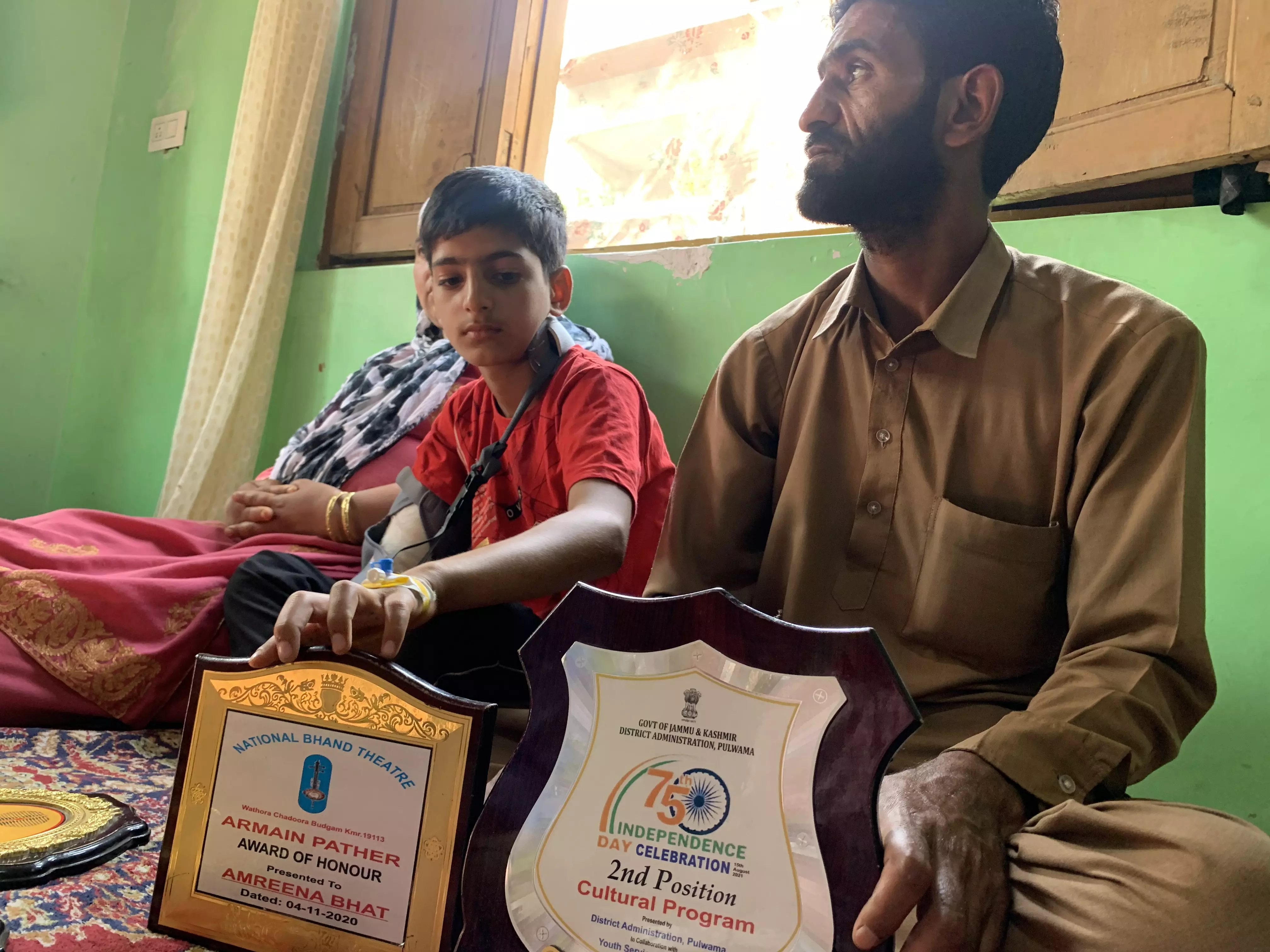 Raziya Bano, her husband, and their son show the trophies Ambreen had received. Photo: Adnan Bhat Raziya Bano, her husband, and their son show the trophies Ambreen had received. Photo: Adnan Bhat