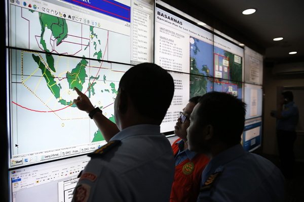 ​Military and rescue authorities monitor progress in the search for AirAsia Flight QZ8501  inside the National Search and Rescue Agency in Jakarta on Dec 29th, 2014 (Credit: Reuters)