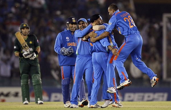 India's Singh is congratulated by teammates after taking wicket of Pakistan's Akmal during their ICC Cricket World Cup 2011 semi-final match in Mohali