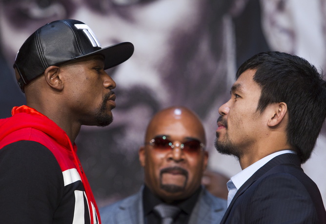 Undefeated WBC/WBA welterweight champion Floyd Mayweather Jr. (L) of the U.S. and WBO welterweight champion Manny Pacquiao of the Philippines face off during a final news conference at the MGM Grand Arena in Las Vegas