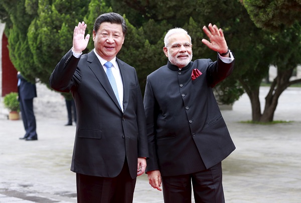 Chinese President Xi looks on as Indian Prime Minister Modi receives a golden Buddha statue from Buddhist abbot of Dacien Temple in Xian