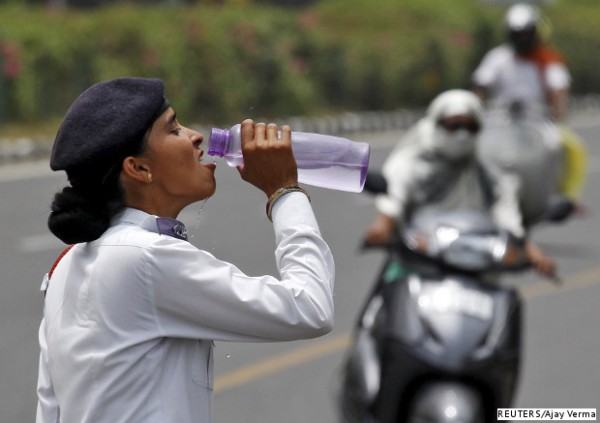 A traffic policewoman in Chandigarh trying to get some relief from the heat with a drink of water.