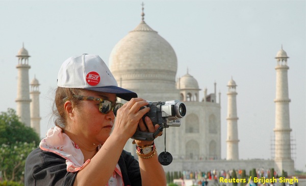 A tourist takes a photograph in front of the Taj Mahal in the tourist city of Agra