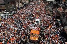 The image shows PM Modi on a truck covered with flowers in the middle of the road with people all around him. It is an old picture of him from a roadshow in Varanasi in 2014 when Narendra Modi had filed his nomination in Varanasi. 